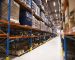 Interior of large distribution warehouse with shelves stacked with palettes and goods ready for the market.